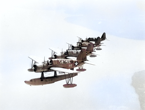A formation of OS2U Kingfisher aircraft in flight, 1943 [Colorized by WW2DB]