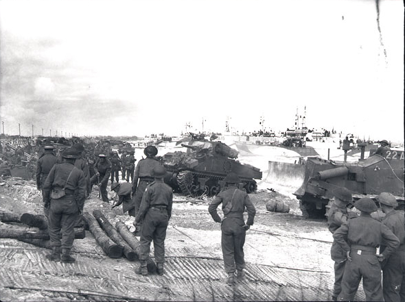 M4 Sherman tanks and men of the Canadian 7th Infantry Brigade landing on a crowded beach at Courseulles-sur-Mer, Normandy, France, 6 Jun 1944