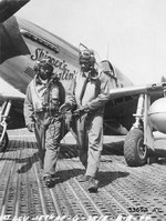 Capt Andrew D Turner, 100th Fighter Squadron CO, and Lt. Clarence P. (Lucky) Lester on the Marsden Matting of Ramitelli Airstrip, Italy. Behind them is Maj Turner’s P-51C “Skipper’s Darlin’ III.” 1 Aug 1944. Photo 2 of 2.