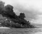 Black smoke pours from fuel oil fires on Battleship Row, Dec 7, 1941. Capsized Oklahoma at left with masts of Maryland, Tennessee, West Virginia, and Arizona in Pearl Harbor, Oahu, Hawaii.