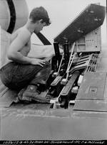 Marine Pfc C.H. McClure servicing the three Browning M2 .50 caliber machine guns in the right wing of an F4U-1 Corsair fighter on Bougainville, Dec 9, 1943