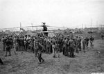 Marines and Army ground crews look over the first Sikorsky R-4 helicopter to land in the fighter strip on Iwo Jima, Mar 23, 1945.