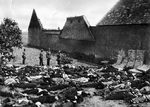 Lidice, Czechoslovakia 10 Jun 1942. SS officer standing over the bodies of all 173 of the village’s men in the garden at the Horák family farm. The mattresses were put up against the stone wall to prevent ricochets.