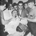 Captain Dixie Kiefer, badly injured in an air attack four days earlier, addressing his crew one more time before being transferred from USS Ticonderoga to the hospital ship Samaritan at Ulithi, 25 Jan 1945.