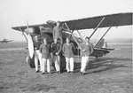 Italian Air Force personnel posing before a CR.32 biplane fighter, circa 1940-1942; note Ju 87 Stuka dive bomber in background
