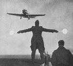 British Skua aircraft approaching a carrier for landing, circa late 1930s