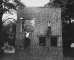 Two Operation Jedburgh personnel scaling a brick wall in training, Milton Hall, Cambridgeshire, England, United Kingdom, circa 1944