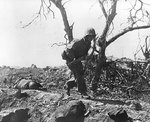 A US Marine ran past a dead Japanese soldier, Iwo Jima, Japan, 3 Mar 1945