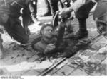 Polish resistance fighter surrendering from his position in the sewers, Mokotów District, Warsaw, Poland, 27 Sep 1944, photo 1 of 2
