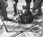 Polish resistance fighter surrendering from his position in the sewers, Mokotów District, Warsaw, Poland, 27 Sep 1944, photo 2 of 2
