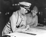Richmond Turner and Alexander Vandegrift aboard USS McCawley looking at maps of the Tulagi-Guadalcanal operation in the Solomon Islands, circa Jul-Aug 1942