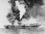 HMS Formidable burning after being struck by a Japanese special attack aircraft in the Pacific Ocean off Sakishima Islands, Japan, 4 May 1945
