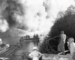 Men watched as firefighters battled flames on LST-480, 22 May 1944; the explosion took place on the previous day