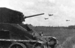 BT-2 tank with 35mm gun of the Soviet Mechanized Brigade Named After K. B. Kalinovsky, Soviet Union, 1933; note Polikarpov R-5 reconnaissance aircraft in background