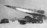 Soviet BM-13 Katyusha rocket launcher mounted on a ZiS-151 truck firing a rocket, 1960s; note BM-21 rocket launcher on a Ural-375D chassis at left