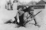 Instructional or propaganda photograph of a Japanese Army soldier carrying a wounded comrade, circa 1940s