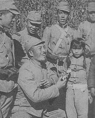 Japanese soldier giving candy to a Chinese girl, 1937-1945