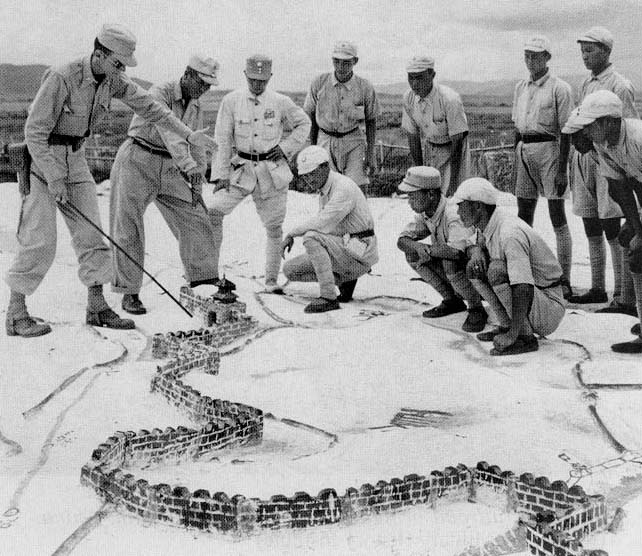 US and Chinese officers and men studying a tactical map in training, 1940s