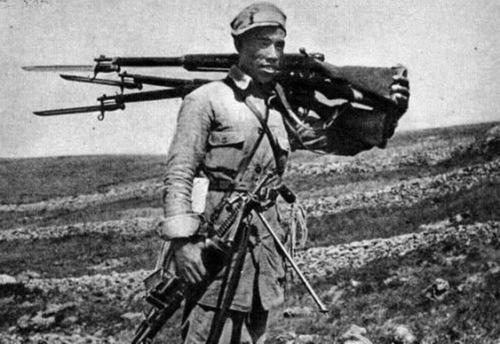 Chinese soldier carrying captured Japanese Type 38 rifles and a Type 11 light machine gun, circa 1940s