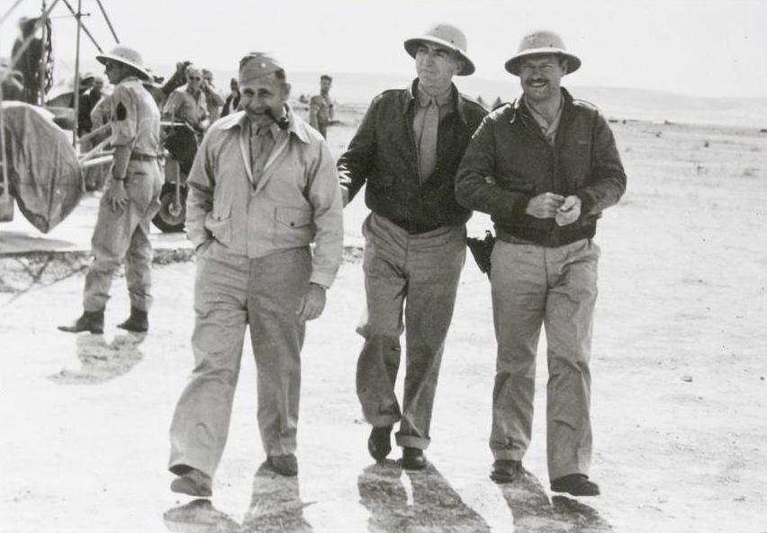 Brigadier General Jimmy Doolittle walks with WWI fighter Ace Eddie Rickenbacker and author Ernest Hemmingway during a tour of North African bases, this time visiting the 414th Bombardment Squadron in Tunisia, 1943