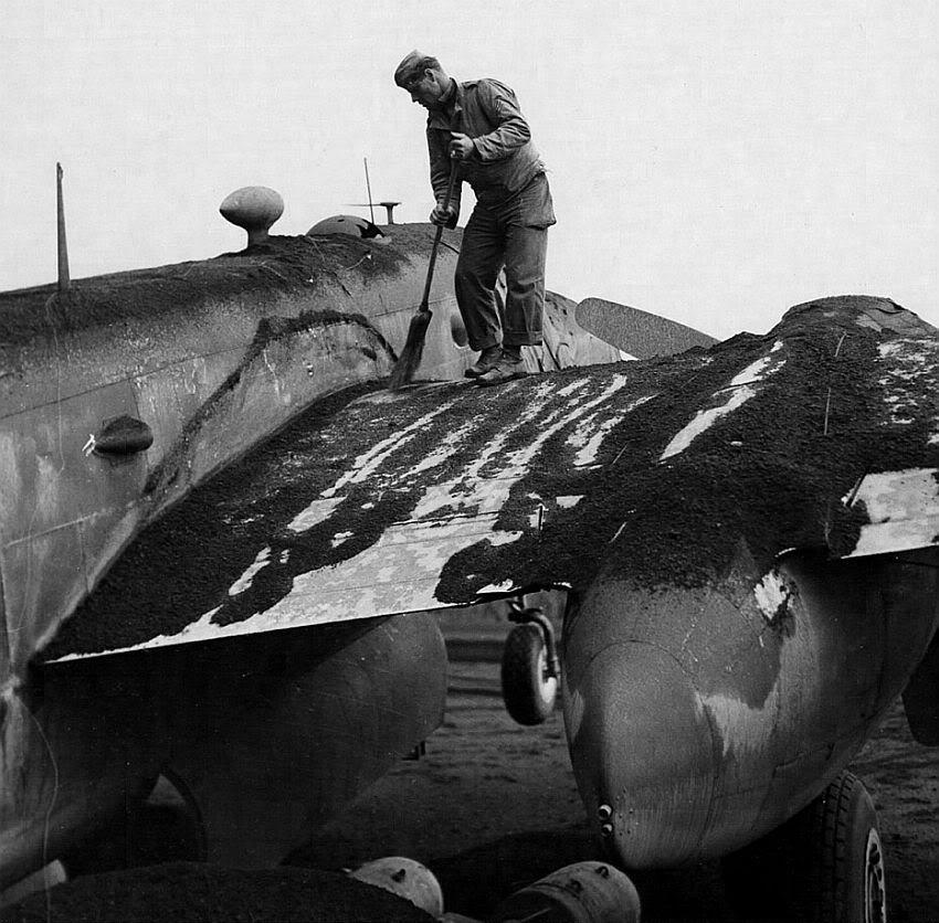 Crew member sweeping ashes off a B-25 of the 340th Bomb Group at Pompeii Field, Italy. Ash came from an eruption of Mt Vesuvius on 23 Mar 1944 that rained hot ash and brimstone on the area damaging several aircraft. Photo 1 of 2.