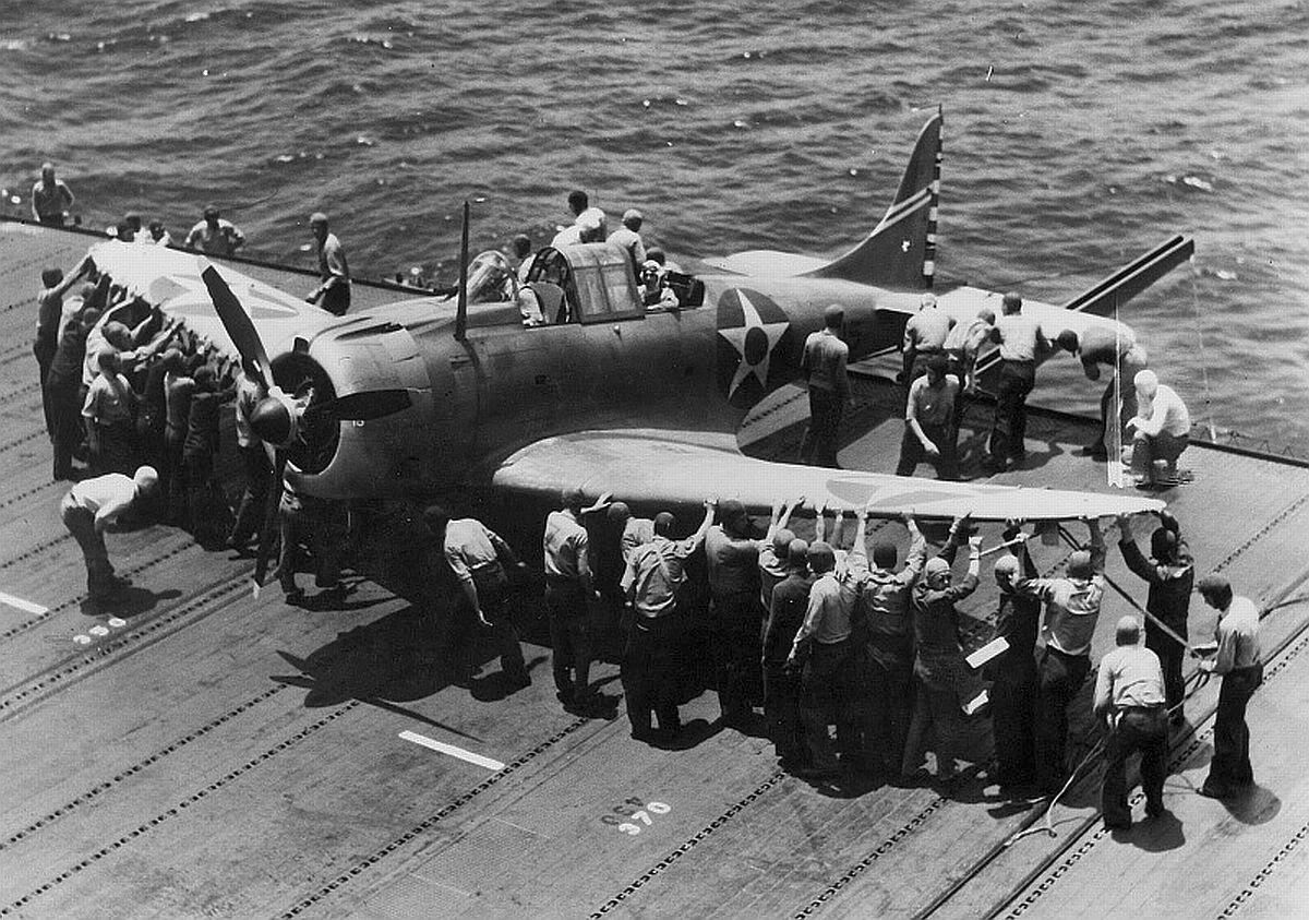 SBD Dauntless dive-bomber being spotted on the flight deck of the Enterprise, Jan-May 1942. Note the groove in the outrigged sponson for the tail-wheel, thus spotting the plane while only using deck space for the front portion.