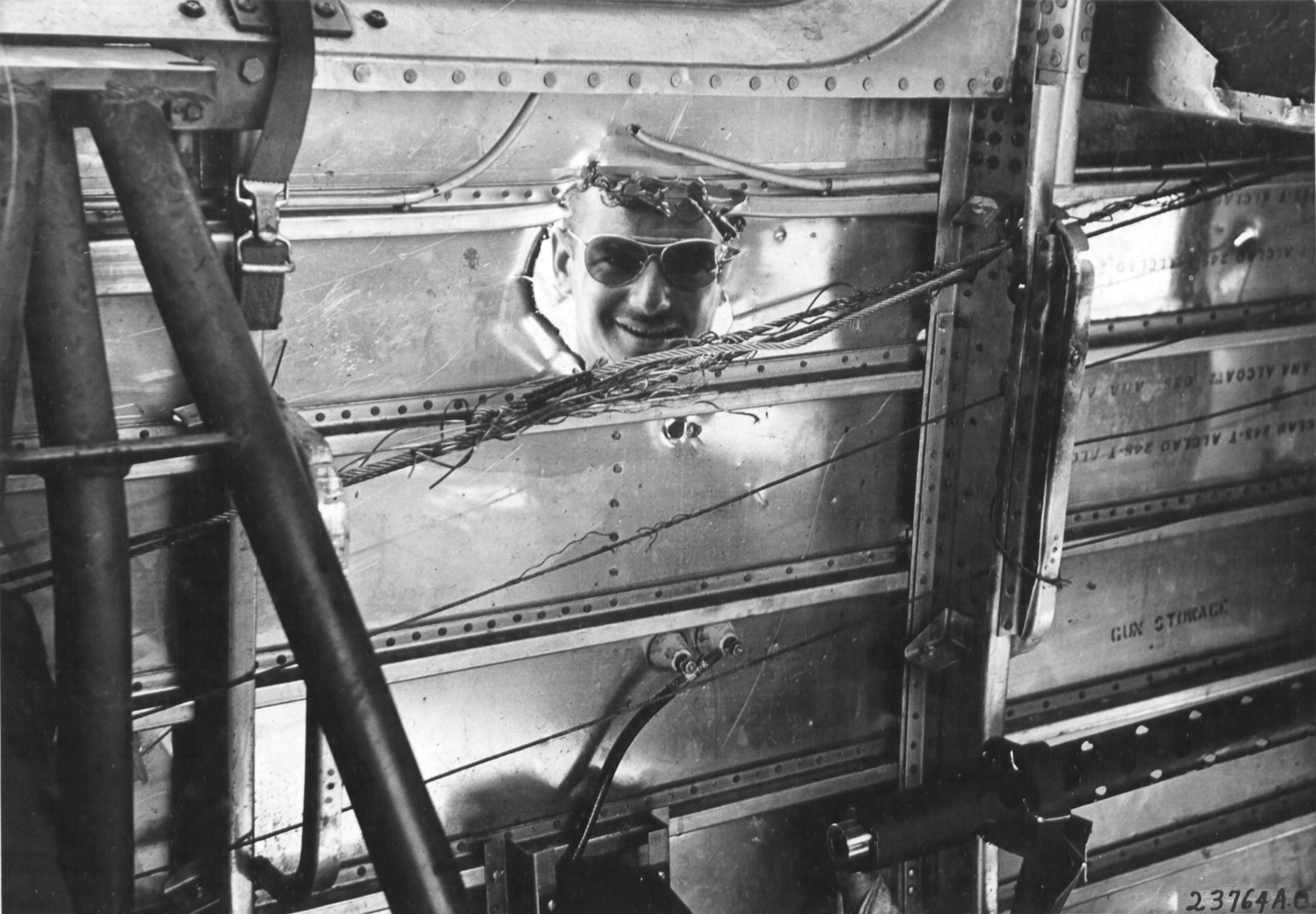 1Lt Charleton 'Hugh' Cuppernell, the co-pilot of this B-24D Liberator 'Superman' peering through a hole in the aircraft from a 20mm shell over Nauru, Apr 20 1943. The photo was taken at Funafuti, Gilbert Islands; photo 1 of 3