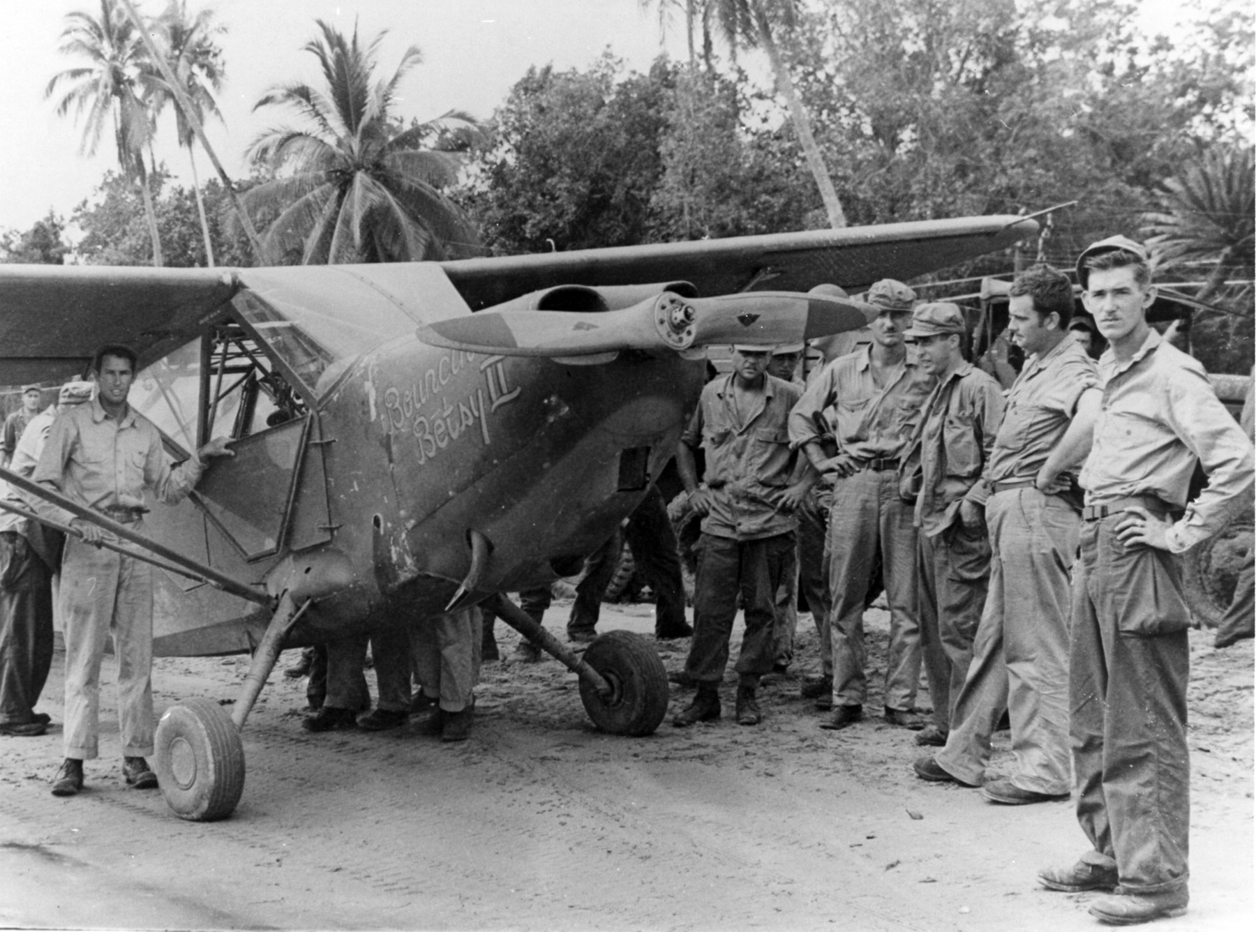 L-5 Sentinel “Bouncing Betsy II” of the 25th Liaison Squadron in New Guinea. Sgt pilots of the “Guinea Short Line” rescued downed fliers and guided fighters to concealed jungle targets. SSGT Jim Nichols standing by the pilot’s door
