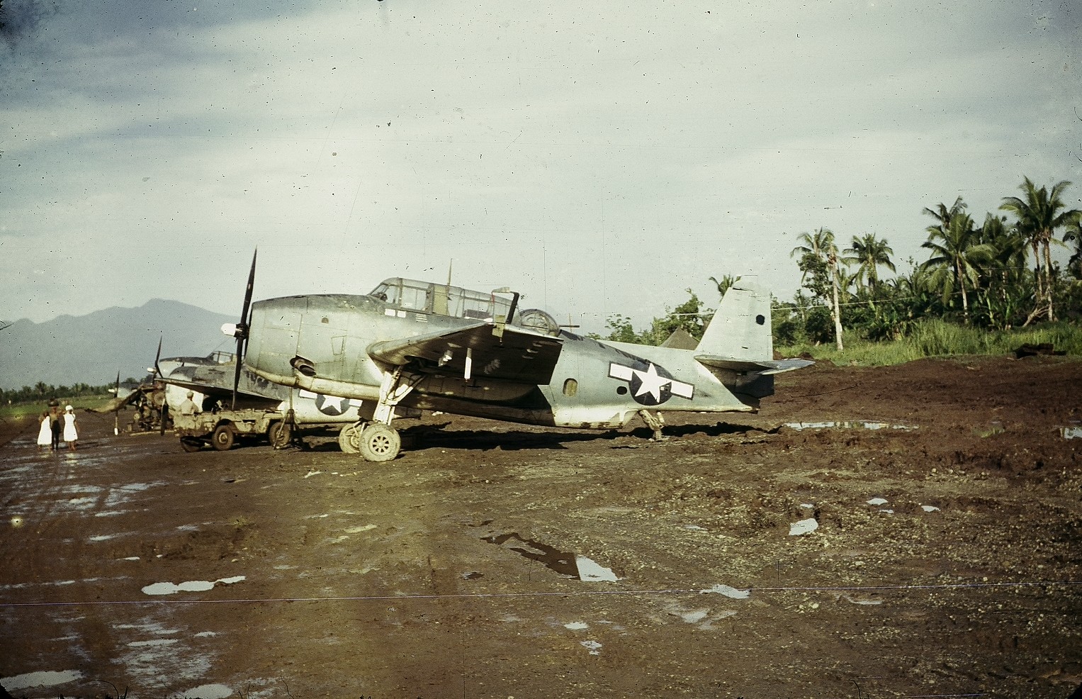 TBM-1C Avengers and an F4F Wildcat, probably with Marine squadrons, lined up at Dulag airstrip, Leyte, Philippines in late 1944 or early 1945.