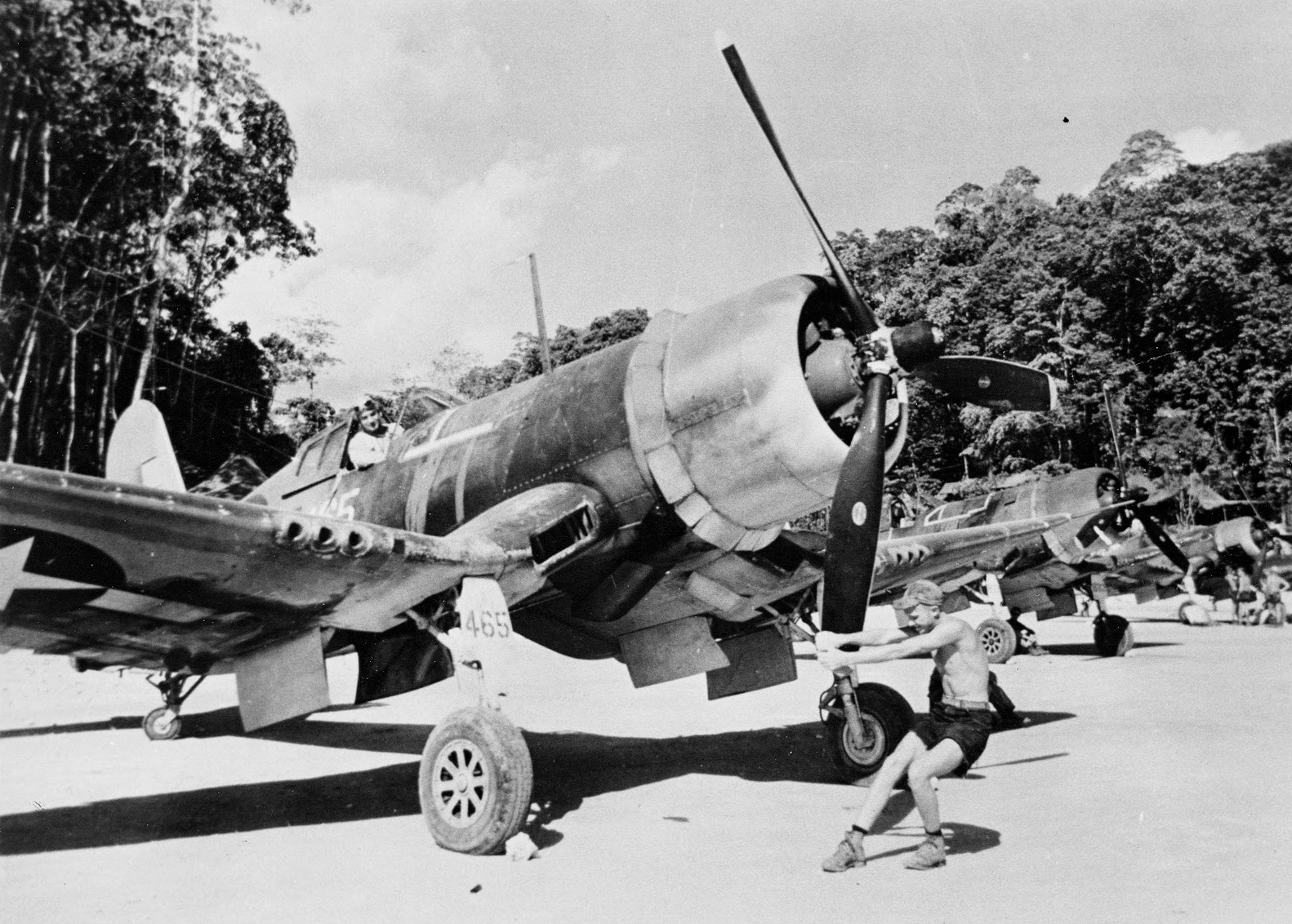 Crewman pulls the propeller through on an F4U-1 Corsair of Marine Fighting Squadron 218 at Barakoma Airfield, Vella Lavella, Solomon Islands, 1943. Note the general sandblasted look of the aircraft after long exposure to tropical winds and coral dust.