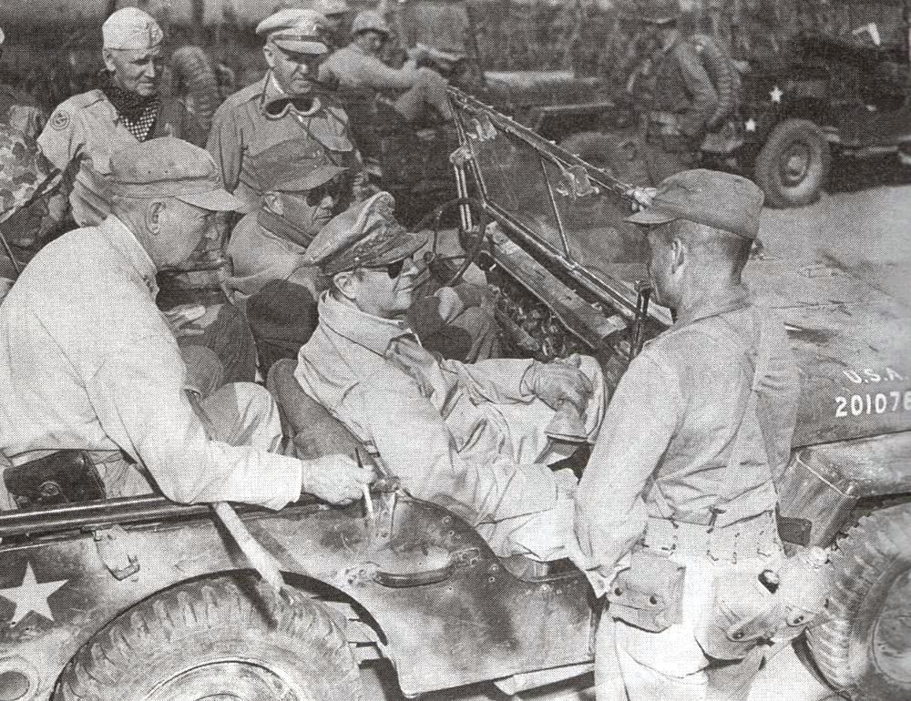 Marine Col Chesty Puller (standing) visited by Army General Douglas MacArthur (seated) as Puller pushed toward Seoul, South Korea, Sep 20 1950. Driving is Army MGen Ned Almond and in the rear are Marine Generals MGen OP Smith & LGen Lem Shepherd.