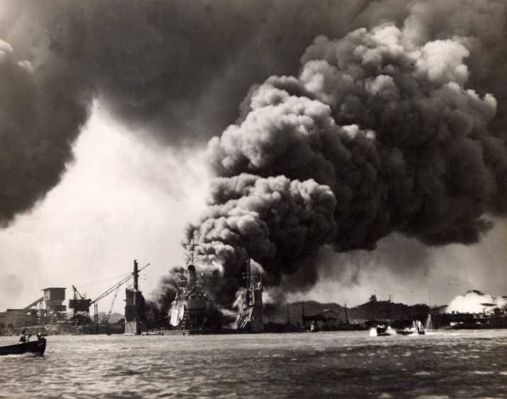 Floating Drydock YFD-2 with destroyer USS Shaw and heavy smoke following the explosion in Shaw’s forward magazine, Pearl Harbor, Oahu, Hawaii, Dec 7, 1941. The burning bow of USS Nevada is at right.
