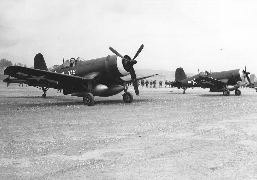 Marine Corps F4U-1D Corsairs prepare for take-off from their base on Okinawa, 1945. Note the two oversized drop tanks beneath the fuselage.
