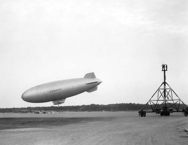 US Navy K-class airship of Airship Patrol Squadron ZP-11 landing at NAS South Weymouth, Massachusetts, United States, Oct 2, 1942. Note sailors atop the mooring mast waiting to secure the blimp.