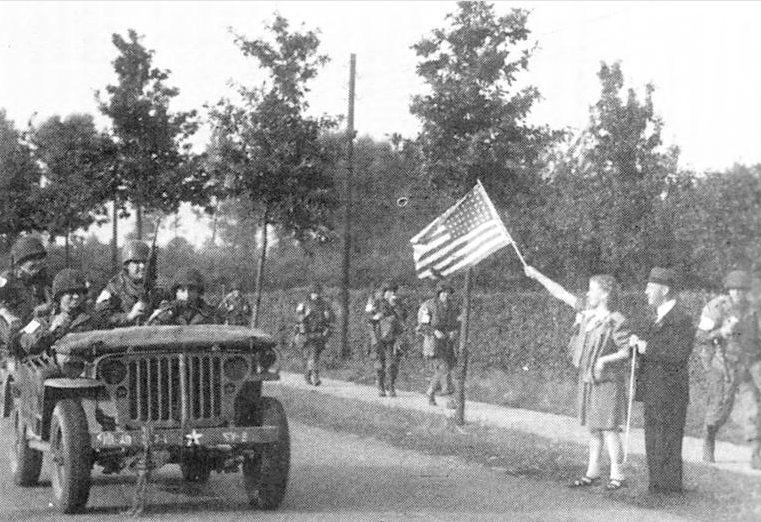 Members of the 327th Glider Infantry Regiment, 101st Airborne, driving from Eindhoven to Nijmegen, Netherlands as part of Operation Market Garden are cheered by Dutch citizens, about Sep 18, 1944.
