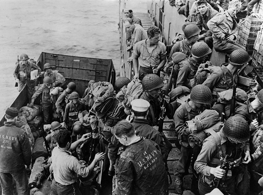US Navy sailors assisting US Army soldiers board a Landing Craft Infantry (Large) (LCI(L)) from an LCVP landing craft, probably in southern England, UK, early June 1944.