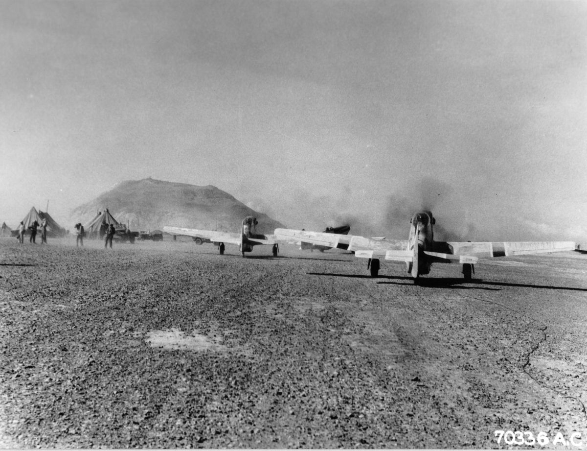 North American P-51D Mustangs of the 47th Fighter Squadron on Iwo Jima prepare for raid on Chichi Jima, Mar 15, 1945. Note Mt Suribachi in the background.