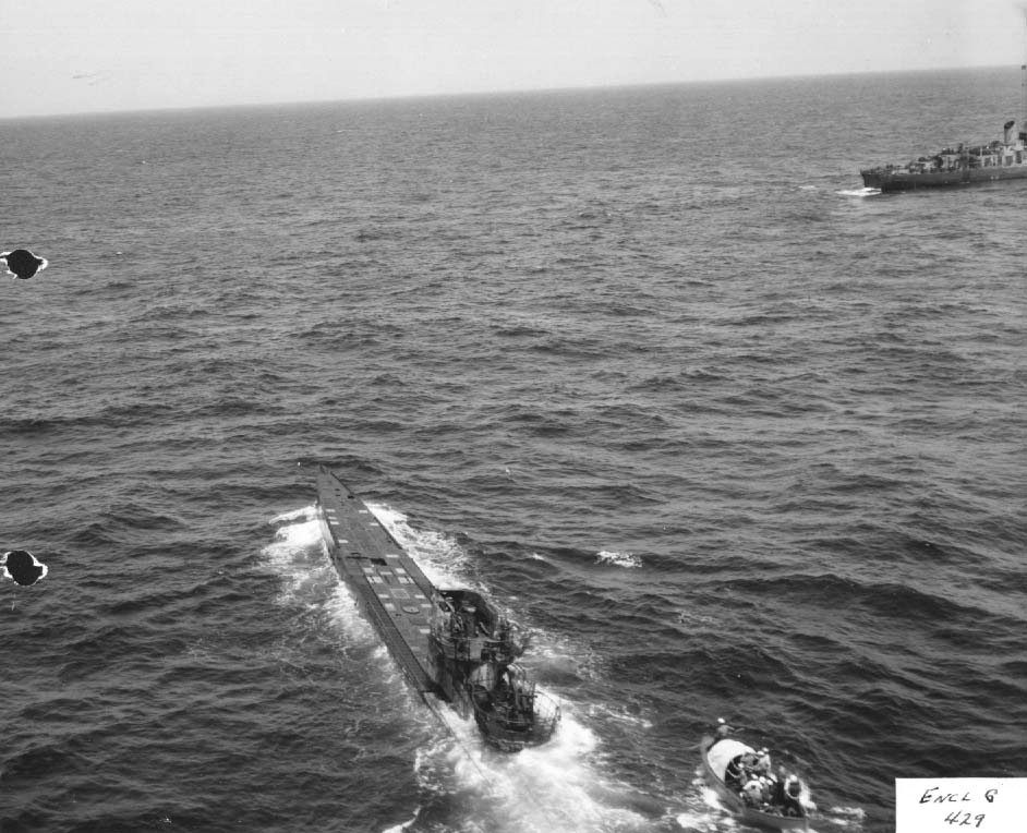 After being abandoned by her crew, an American boarding party comes alongside the damaged German U-505 off the West African coast, 4 Jun 1944. Destroyer Escort USS Chatelain circles the capture.