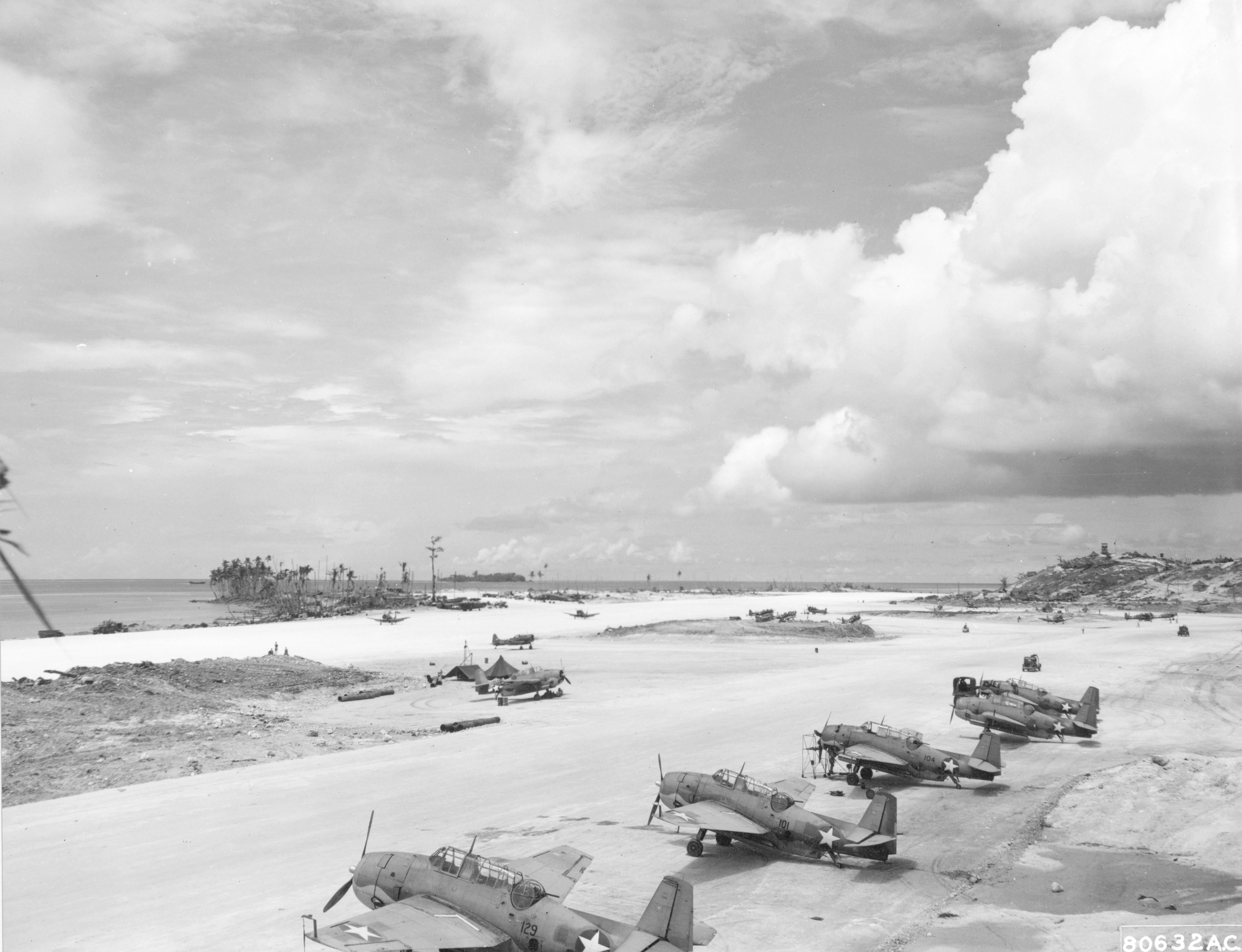 Navy TBF-1 Avengers at the Munda Airstrip, New Georgia, Solomons, Sept 1943. Note the crews are in the process of applying the newly updated National Insignia with white bars and a blue border.