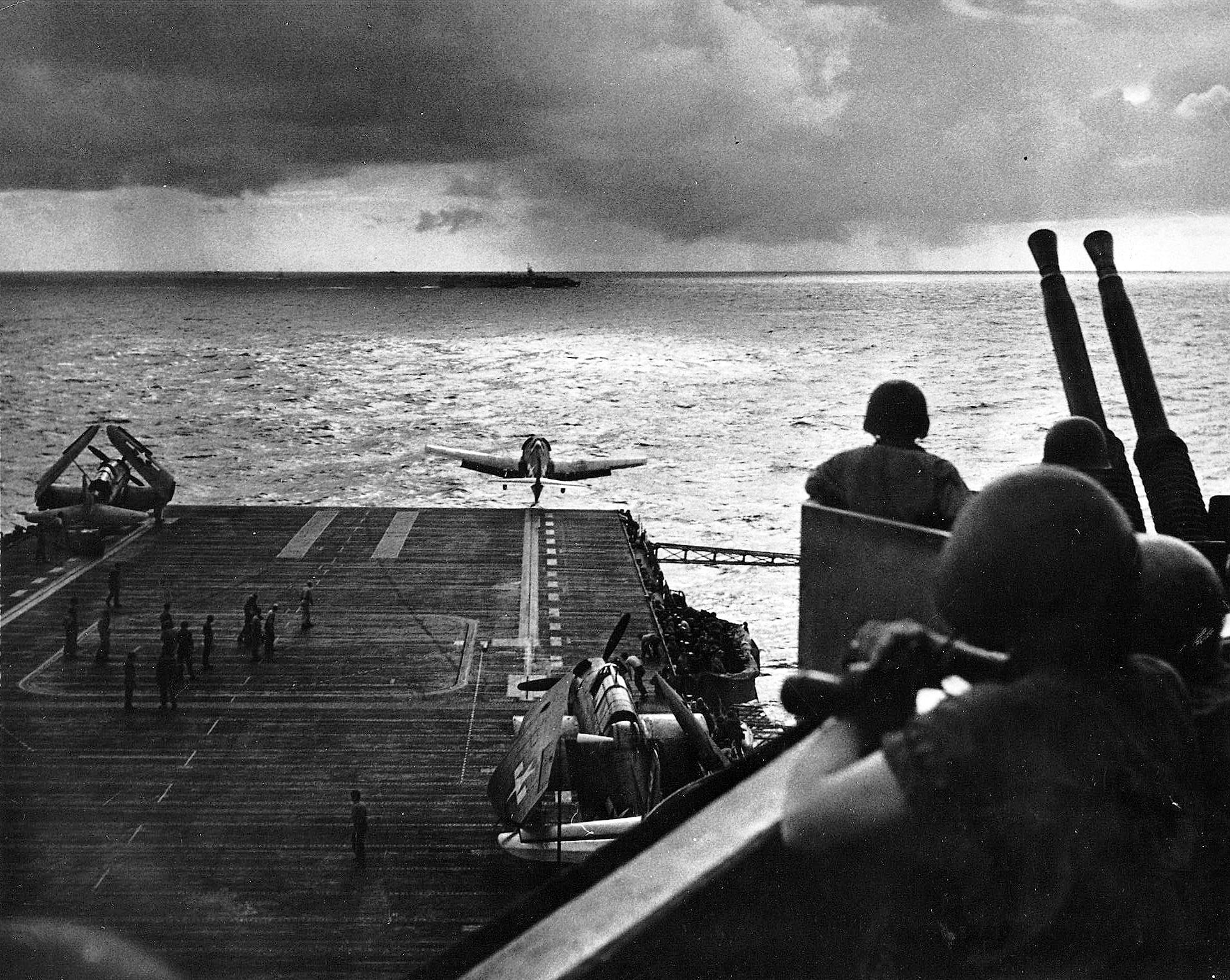 F6F Hellcat launching from USS Intrepid’s starboard catapult, 1945. Note SB2C Helldiver and TBM Avenger spotted on the deck. Note also Independence-class light carrier cutting across Intrepid’s bow.