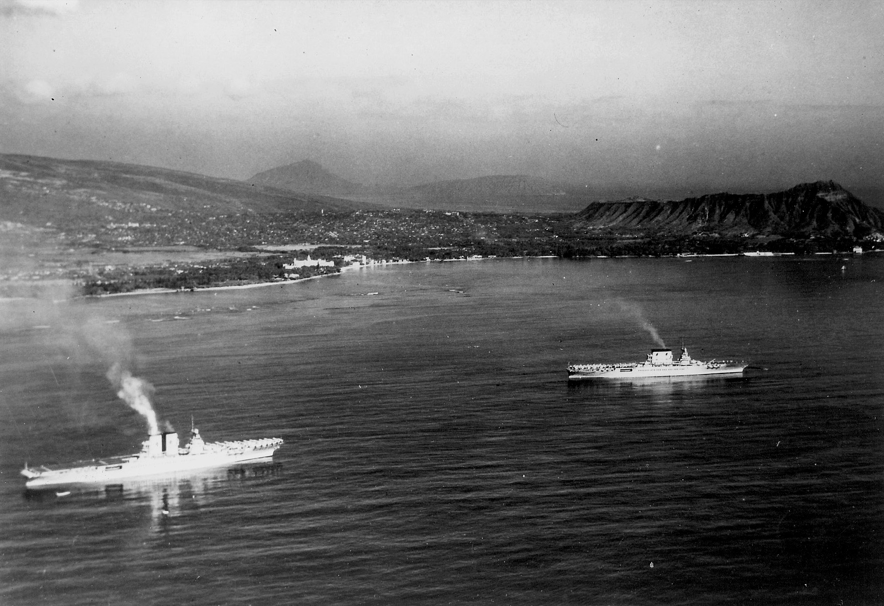 USS Saratoga (left) and USS Lexington (Lexington-class) at anchor off Honolulu, Hawaii, 2 Feb 1933. Note Royal Hawaiian Hotel on Waikiki beach and Diamond Head at right.