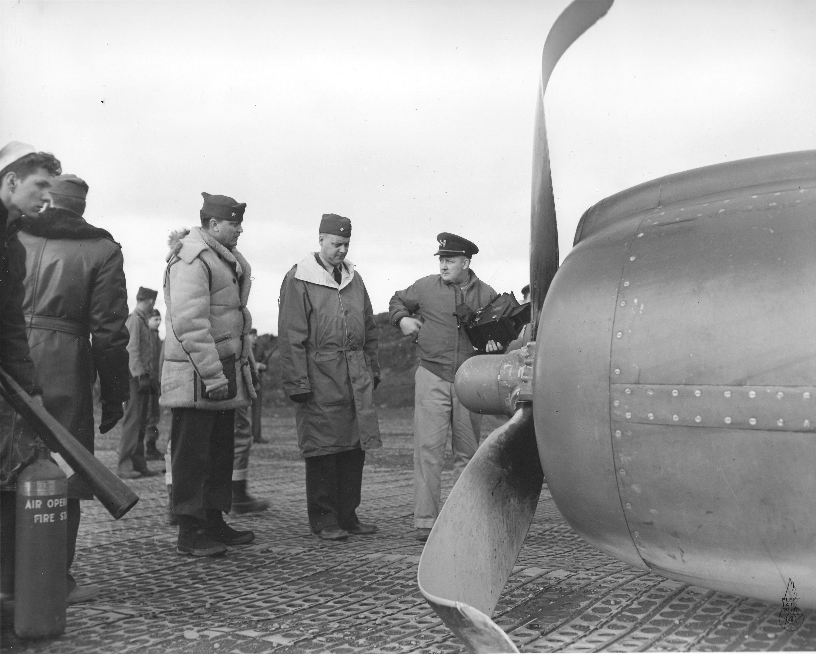 Commodore Leslie Gehres inspecting a PV-1 Ventura of Bombing Squadron VB-139 after a belly landing on Attu Island, Alaska, 18 May 1944. Note the Marsden Matting runway surface