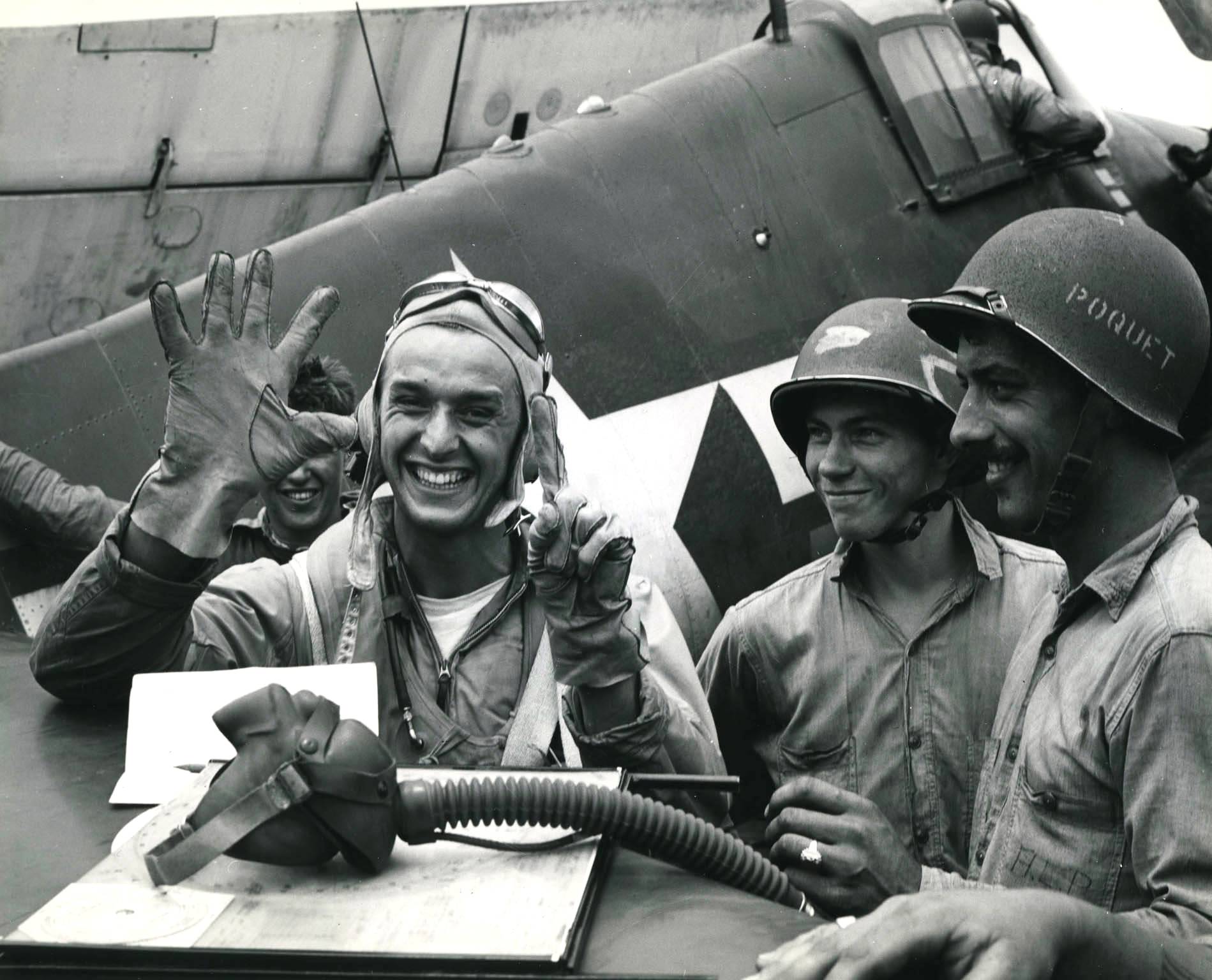 An elated fighter pilot, Alexander Vraciu, showing how many enemy planes he just shot down, his share in the Marianas Turkey Shoot. Fighting Squadron VF-16 aboard USS Lexington (Essex-class), 19 Jun 1944