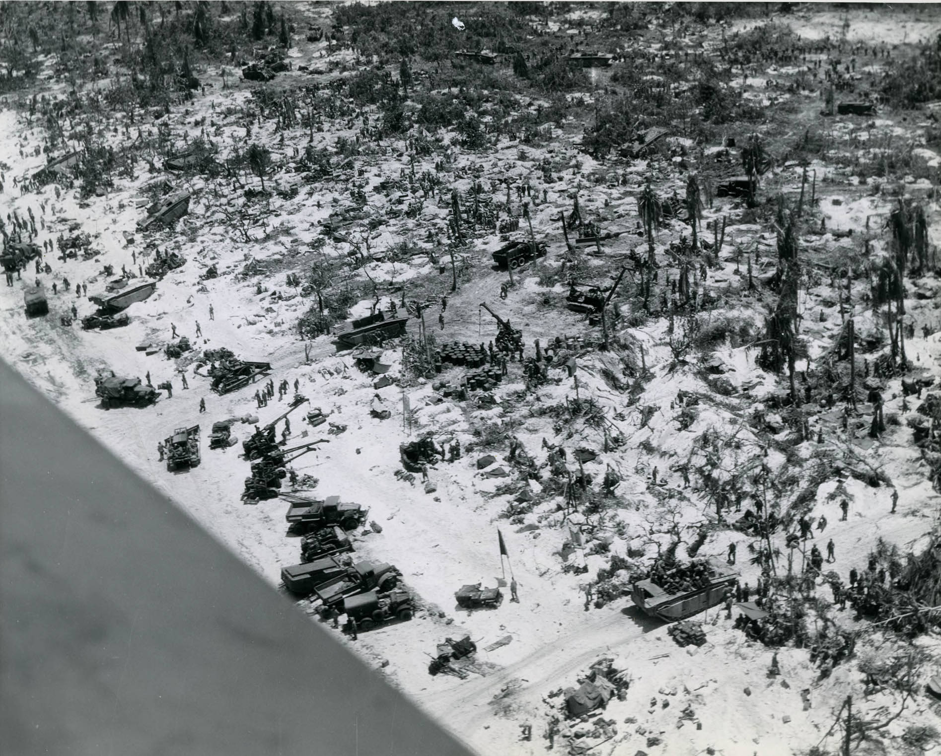 US Marines moving supplies ashore across the beachhead on Peleliu, Palau Islands, late Sep 1944. What appears to be water in the lower left is actually the wing of the photo plane.