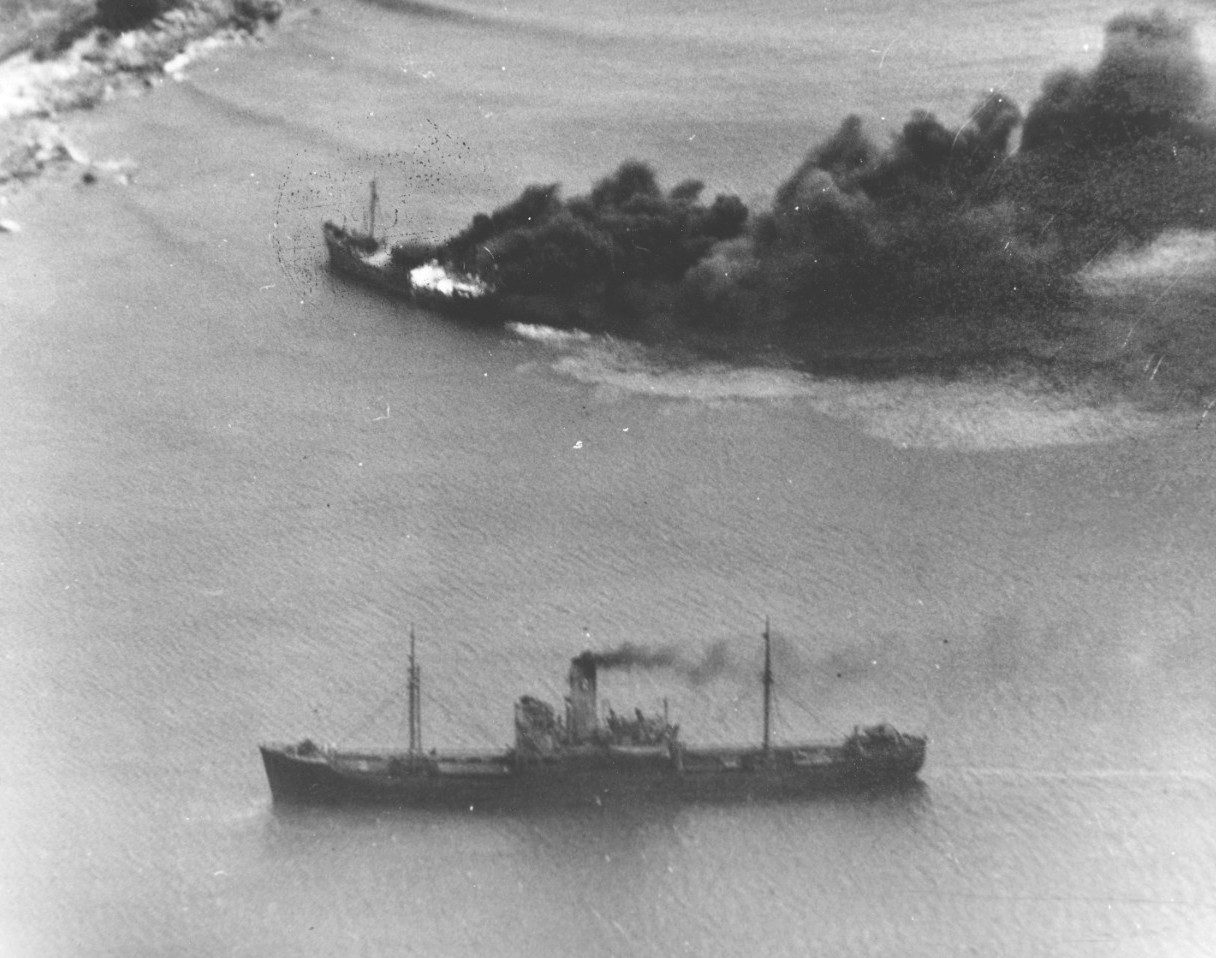 Japanese freighters Shoei Maru beached and burning and Takebe Maru damaged and trailing oil on the coast of French Indochina (Vietnam) north of Qui Nhon after being attacked by 175 USN carrier planes, 12 Jan 1945.