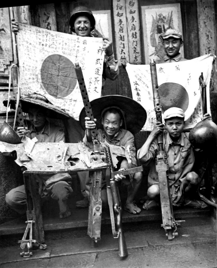 US soldier, Chinese soldier, and Chinese guerrilla fighters displaying captured Japanese flags, Browning machine guns, and MP 34 submachine gun, China, 1940s