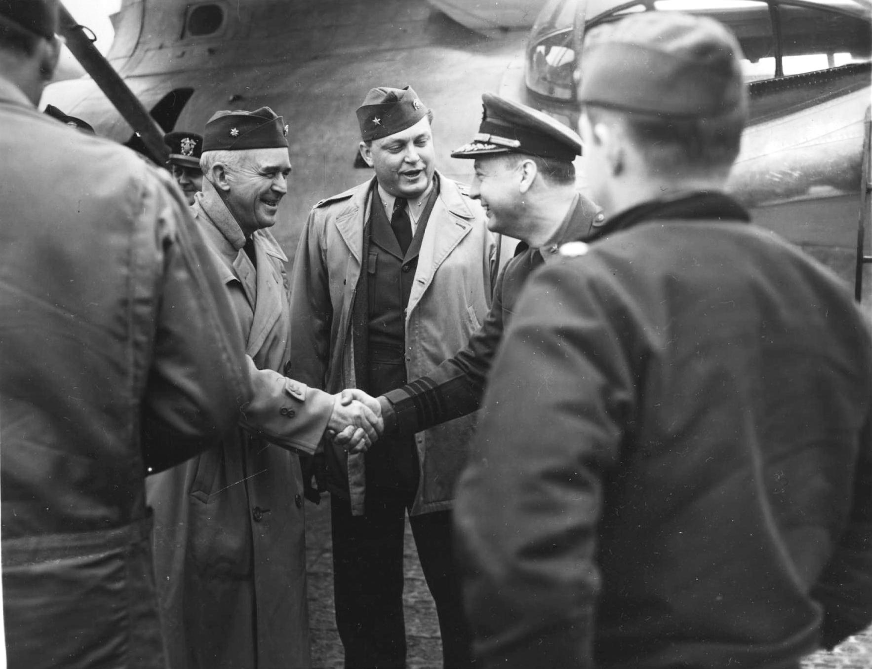 US Navy Commodore Leslie Gehres, commander of Fleet Air Wing 4 in the Aleutians (with his back to the PBY Catalina airplane), making introductions of newly arriving officers at Attu, Alaska, 1944.