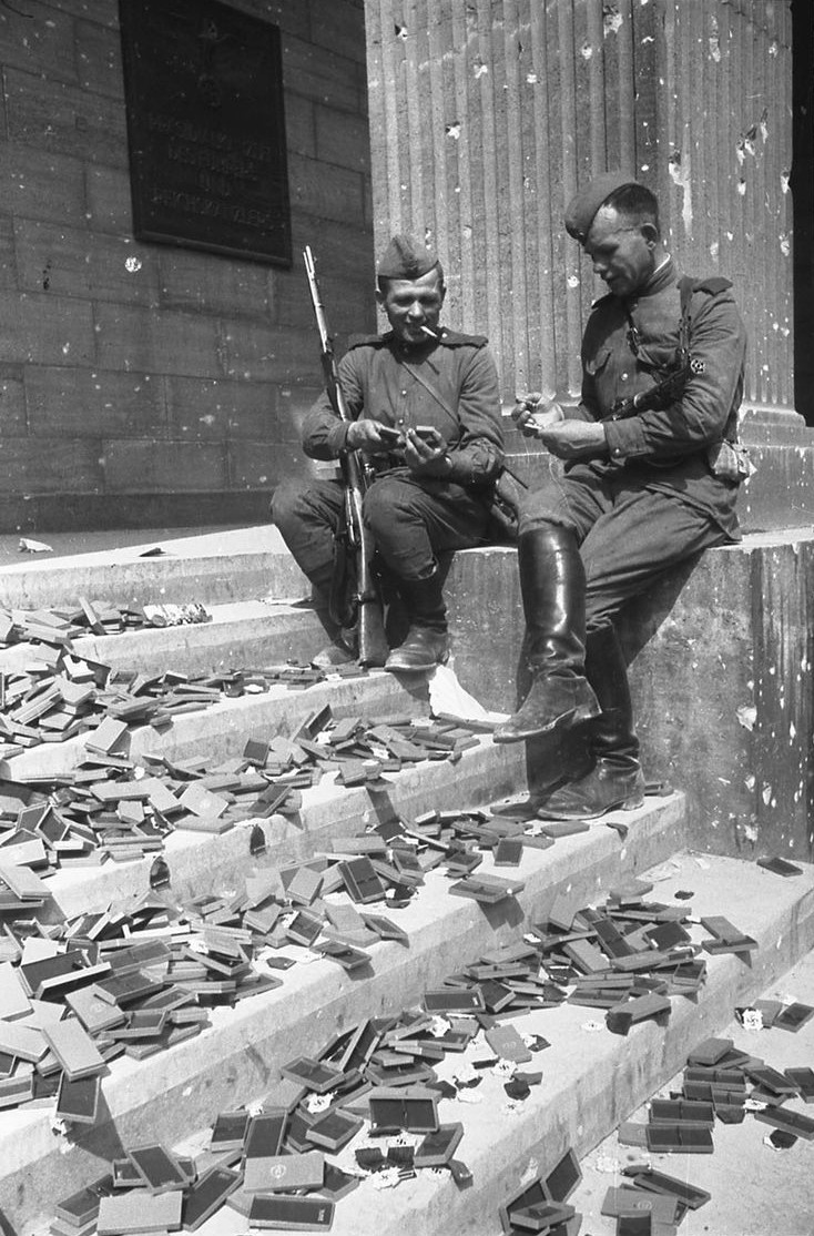 Soviet soldiers studying not-yet-issued German medals on the steps of Reich Chancellery, Berlin, Germany, May 1945