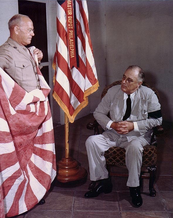 President Franklin Roosevelt being presented with a Japanese flag captured by US Marines on Makin Island by Marine Corps Commandant LtGen Thomas Holcomb, White House, Washington DC, 17 Sep 1942.