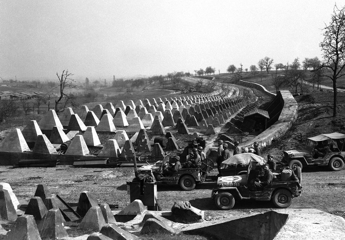Soldiers of the US 7th Army pause at the Siegfried Line on the road to Karlsruhe, Germany, 27 Mar 1945